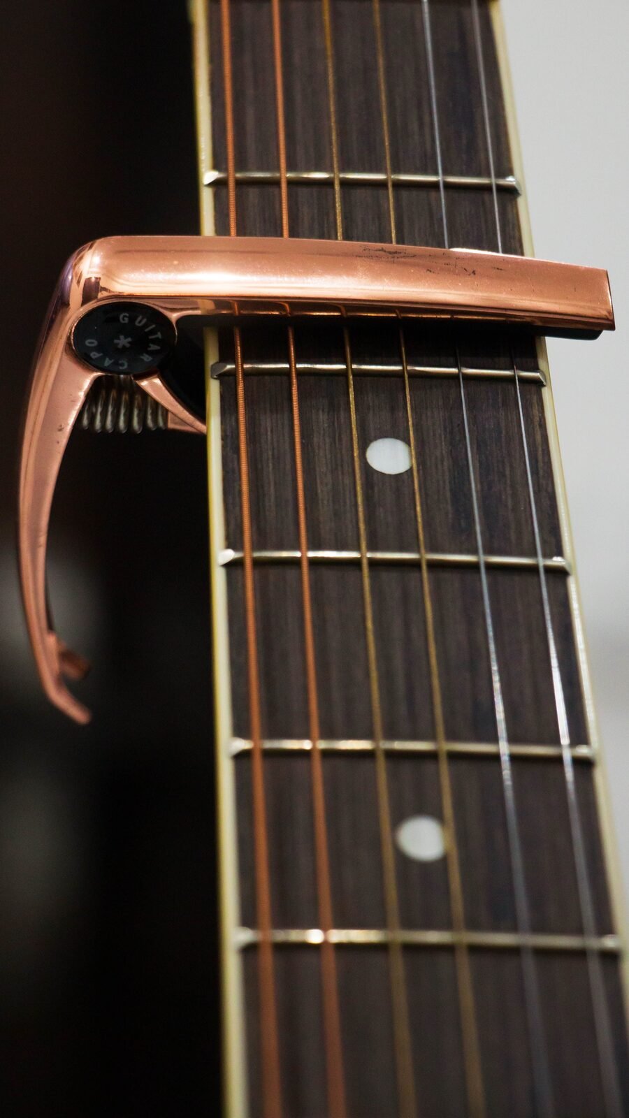 A capo clamped onto a guitar fretboard