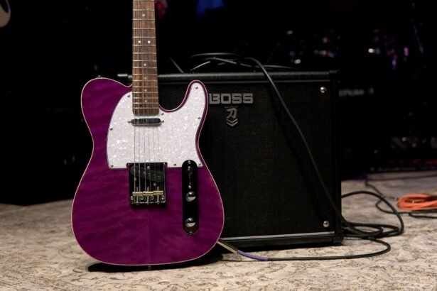 A purple electric guitar leaning against a BOSS combo amplifier on stage