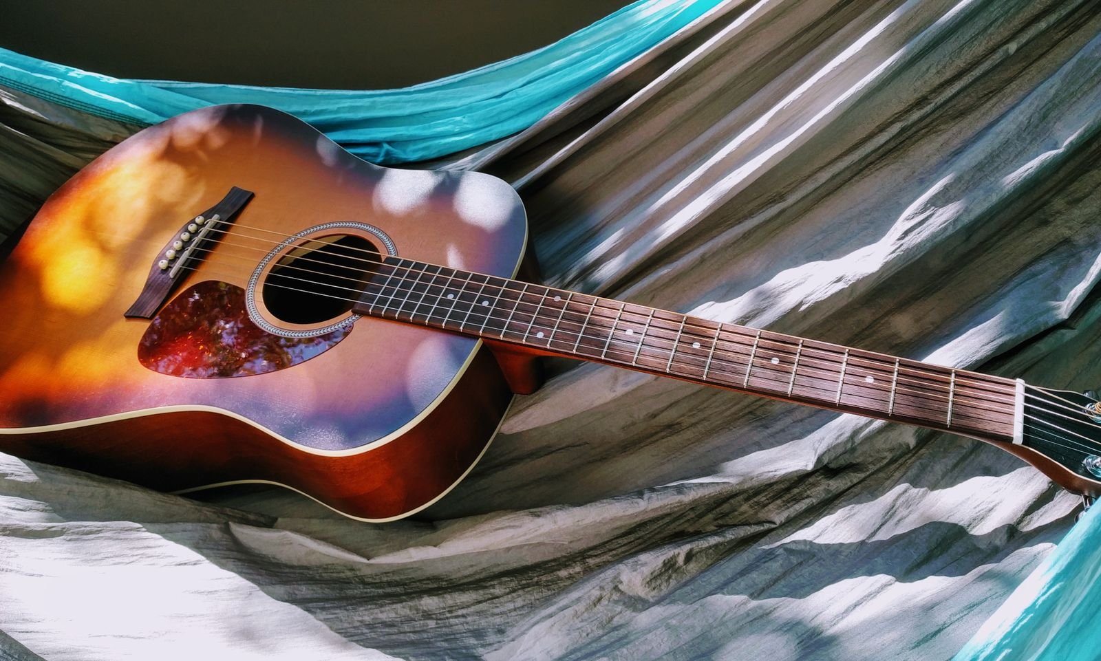 A full-scale acoustic-electric guitar neck and body, illustrating the long neck to small body proportions of an ultra-light travel guitar