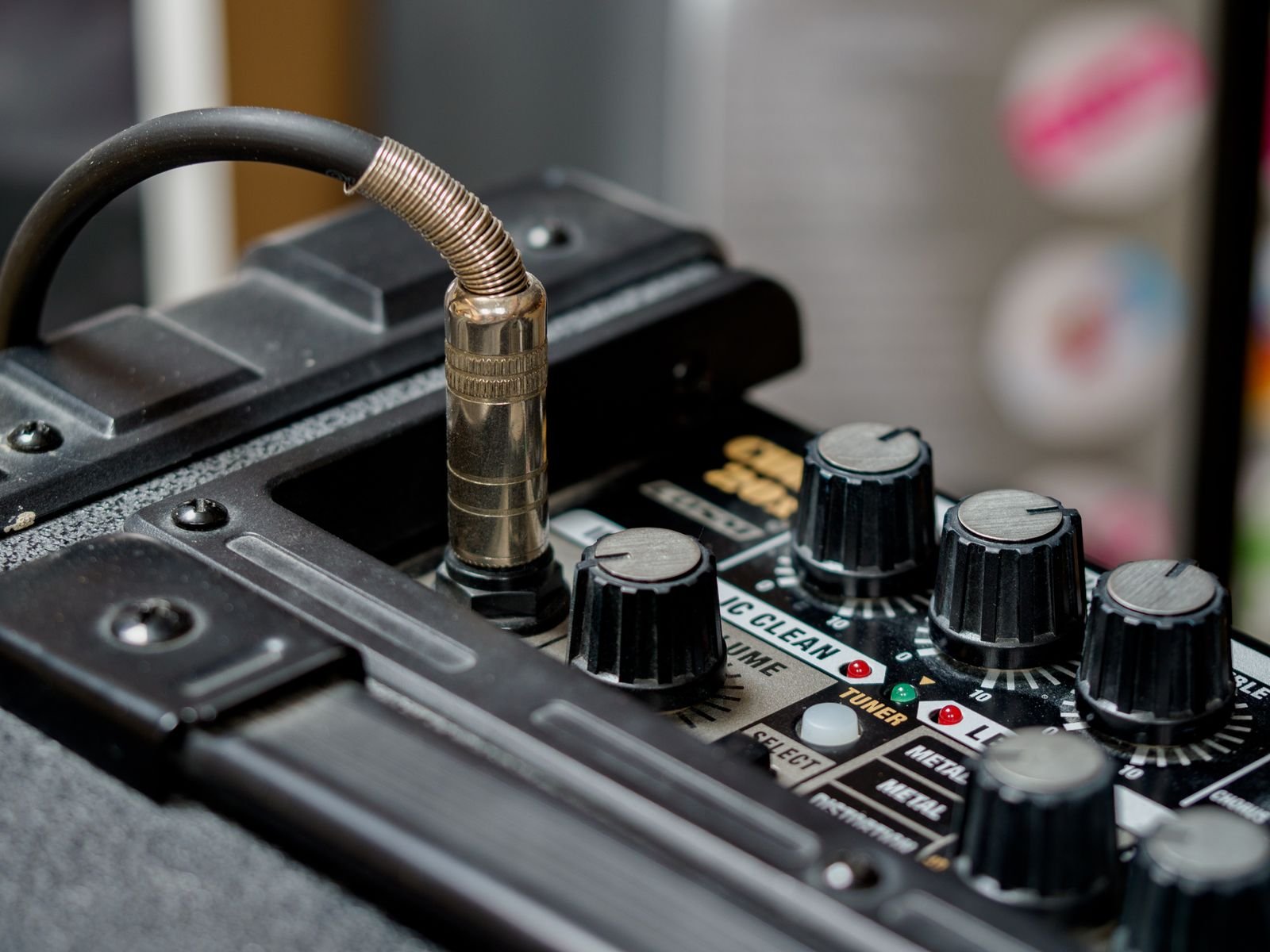 A quarter inch guitar cable plugged into a small practice amplifier, illustrating how a piezo pickup connects without a built-in headphone amp