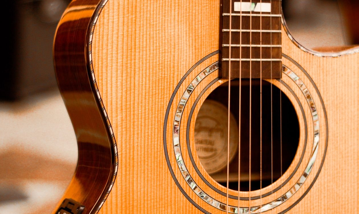 Close-up of an acoustic guitar's spruce top, soundhole and abalone rosette detail