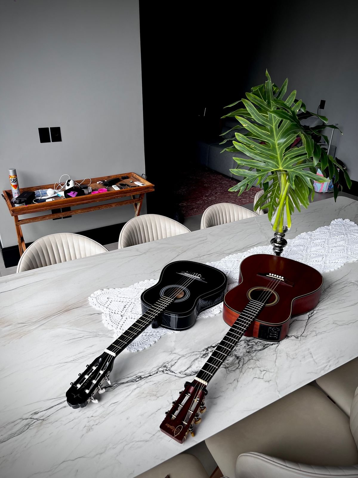 Two acoustic guitars resting on a table at home, illustrating a compact guitar kept ready to pick up
