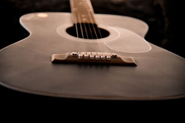 Close-up of an acoustic guitar soundhole and bridge in warm-toned wood, illustrating the small solid body of a travel acoustic-electric