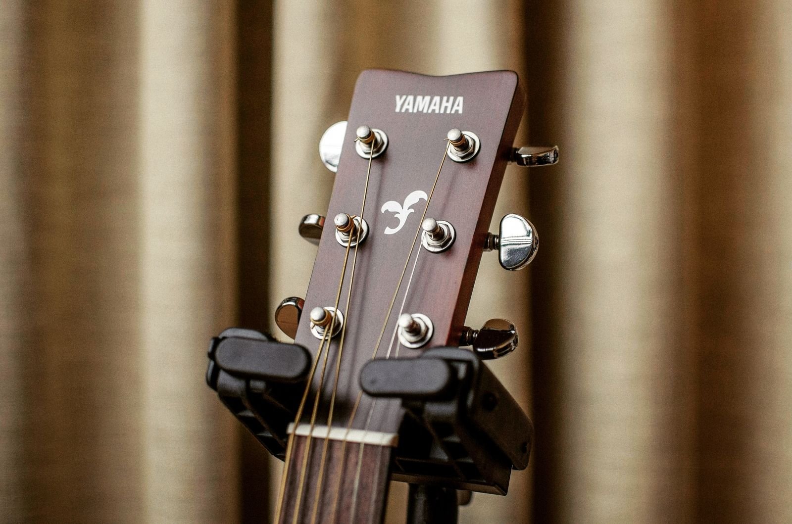 Close-up of a Yamaha acoustic guitar headstock on a stand, showing the Yamaha branding