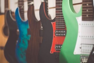A row of electric guitars in a shop, illustrating the kind of solid-body electric feel a travel electric like the HUSH X Live is trying to match