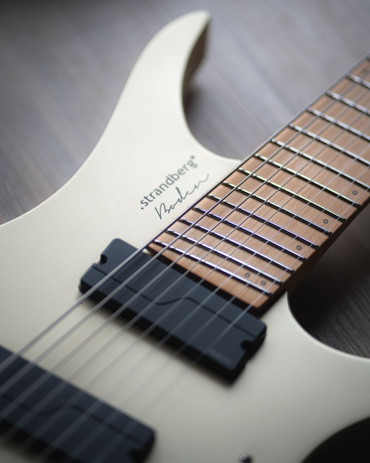 Close-up of a headless electric guitar neck and bridge