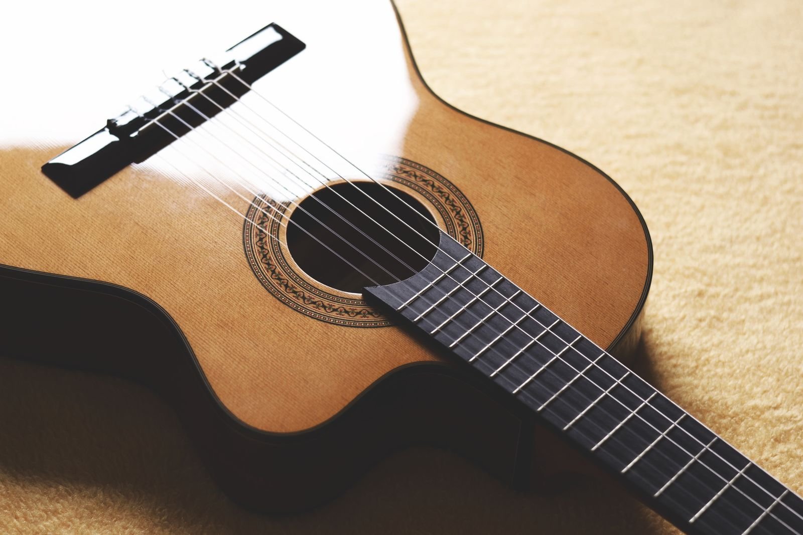 Close-up of a small acoustic guitar soundhole and rosette, the kind of detail that varies most between laminate and solid-top builds