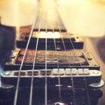 Close-up of a single humbucker pickup and fixed bridge on a solid-body electric guitar