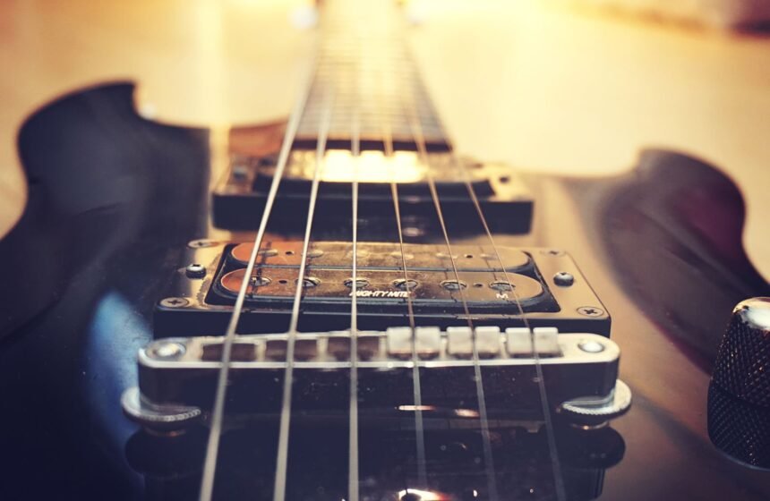 Close-up of a single humbucker pickup and fixed bridge on a solid-body electric guitar
