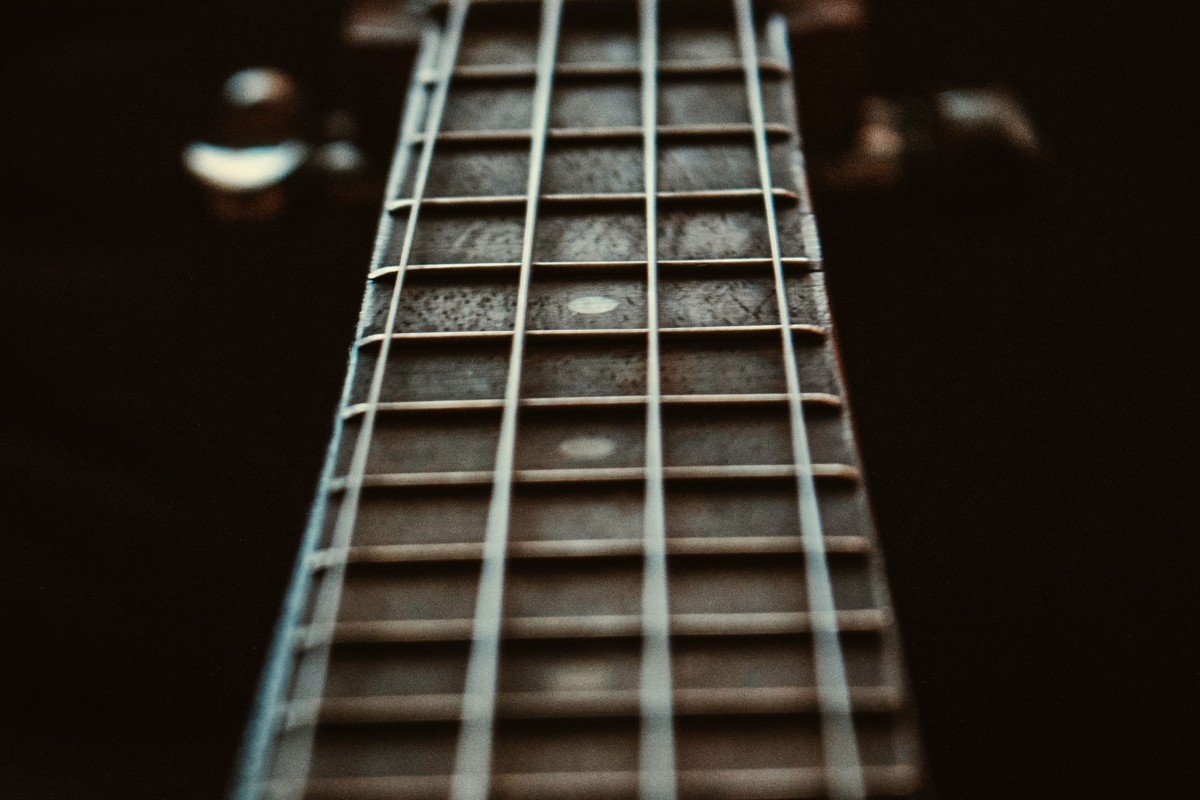 Close-up of a guitar fretboard and frets, the Ortega RGLE18ACA guitarlele has an 18-fret walnut fretboard