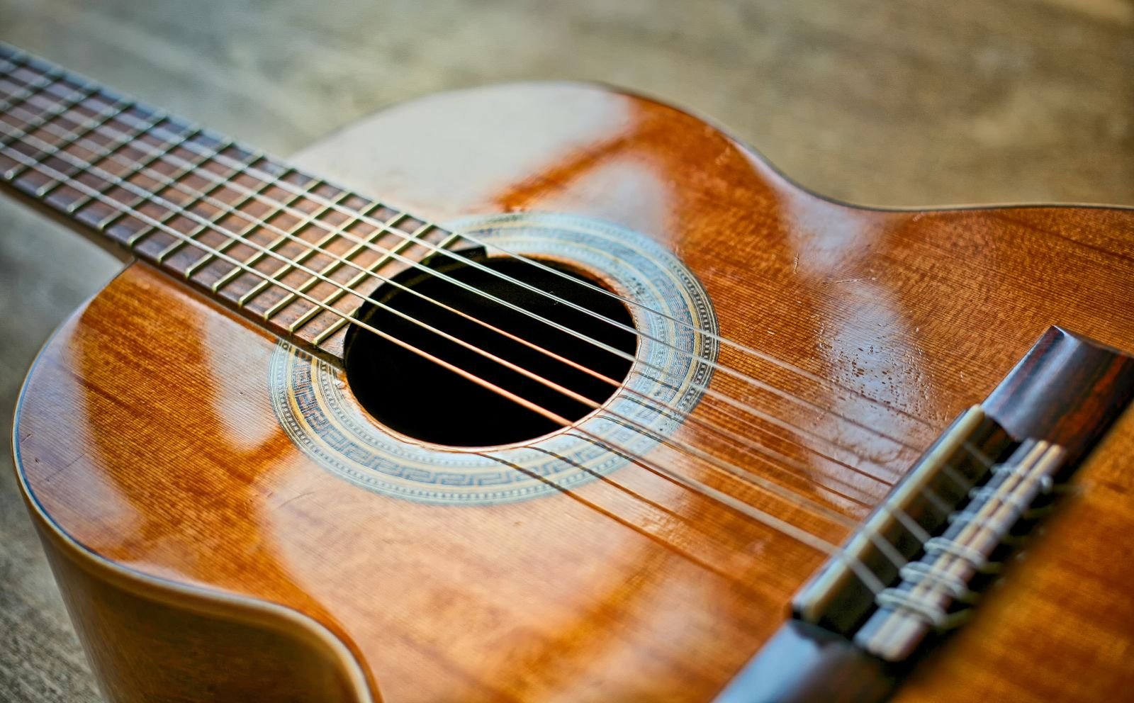 Close-up of an acoustic guitar neck and soundhole on a small-bodied instrument