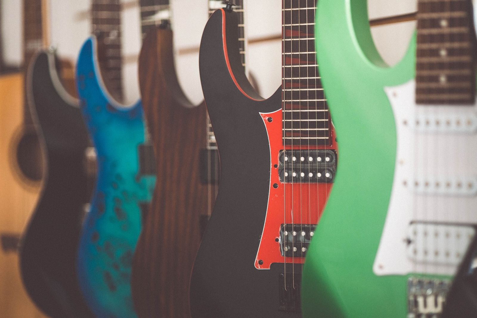 A wall of full-size guitars hanging in a shop