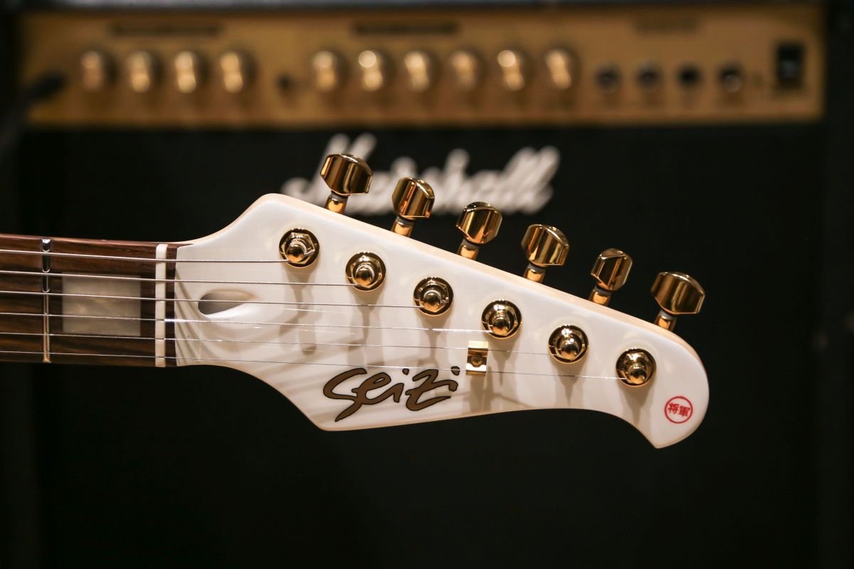 Guitar headstock with an amplifier in the background