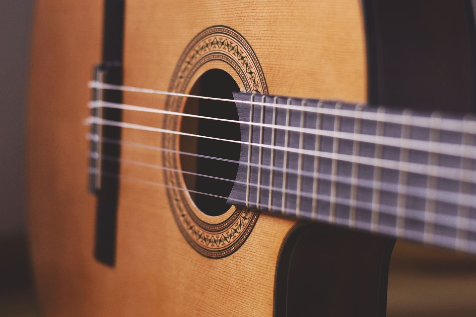 Close-up of nylon strings and the wooden bridge area on a classical-style guitar