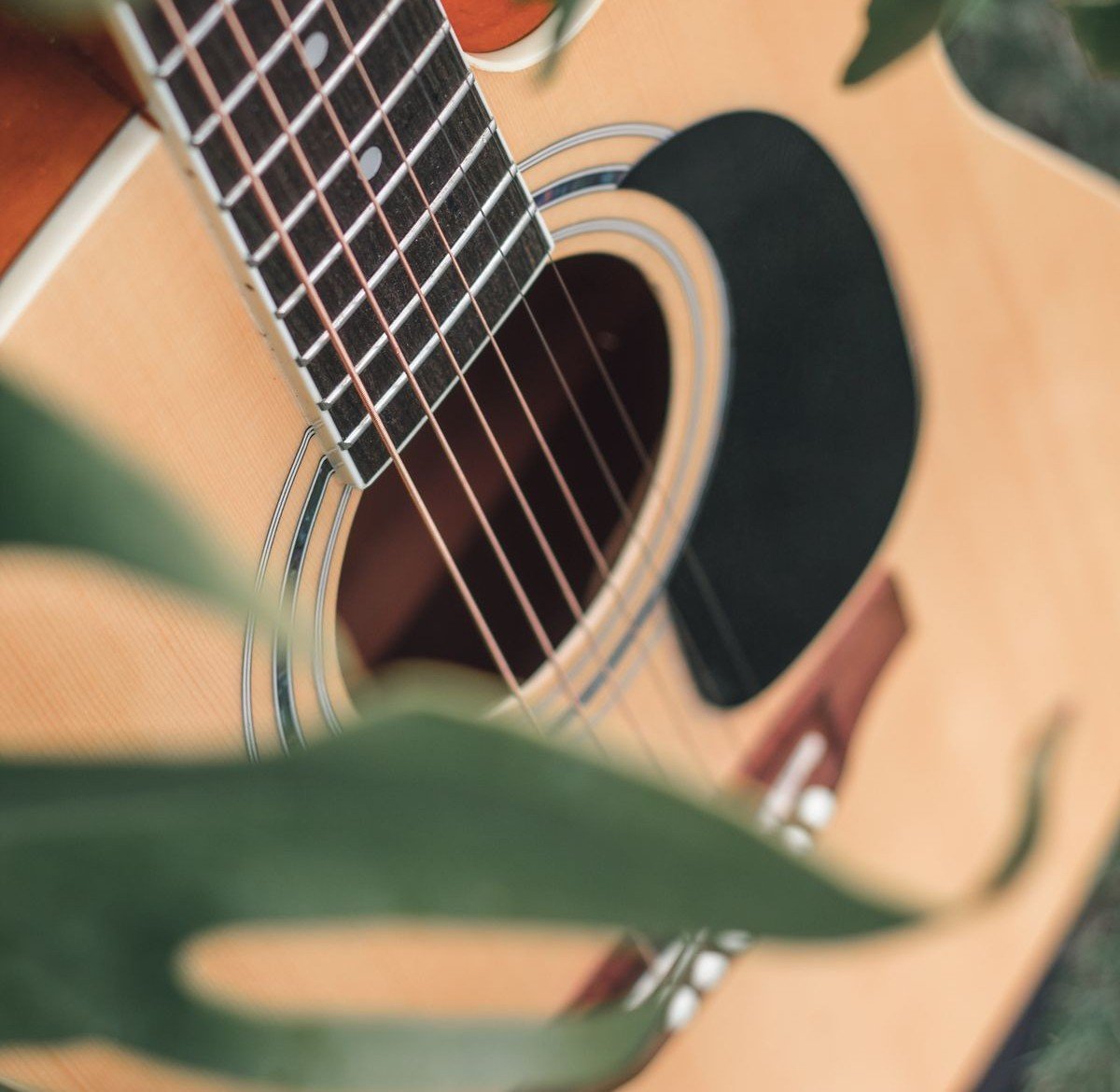 Close-up of a 3/4-size acoustic's fretboard, soundhole and black pickguard, the kind of compact build the Yamaha JR1 uses