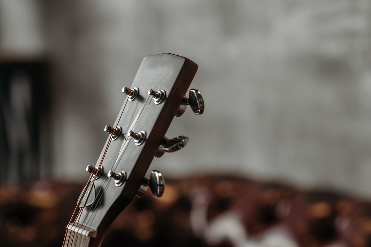 Close-up of a guitar headstock and tuning machines in rosewood and maple tones