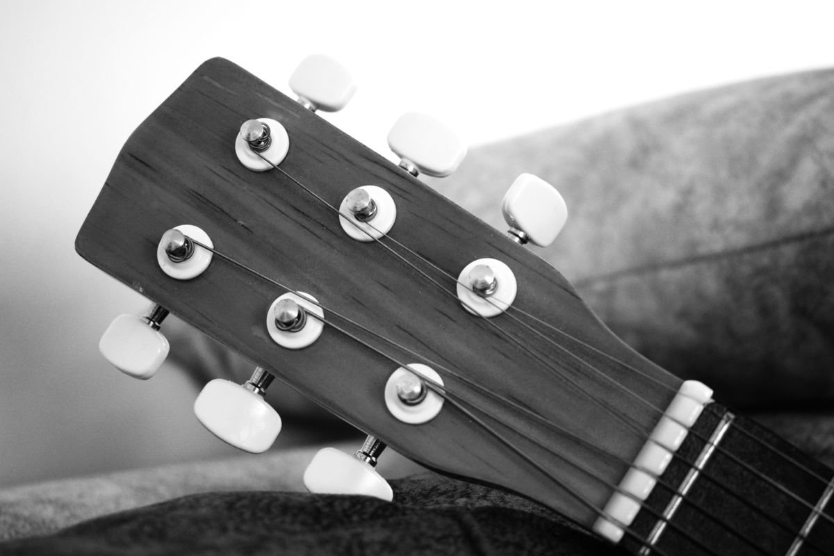 Black and white close-up of guitar tuning machines and headstock