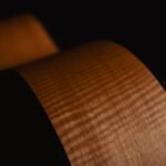 Close-up of an acoustic guitar side showing natural wood grain