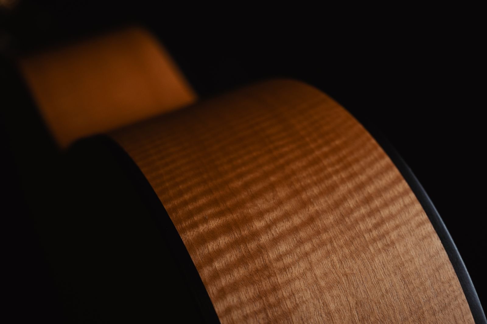 Close-up of an acoustic guitar side showing natural wood grain