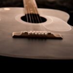 Close-up of an acoustic guitar bridge and strings on the guitar body