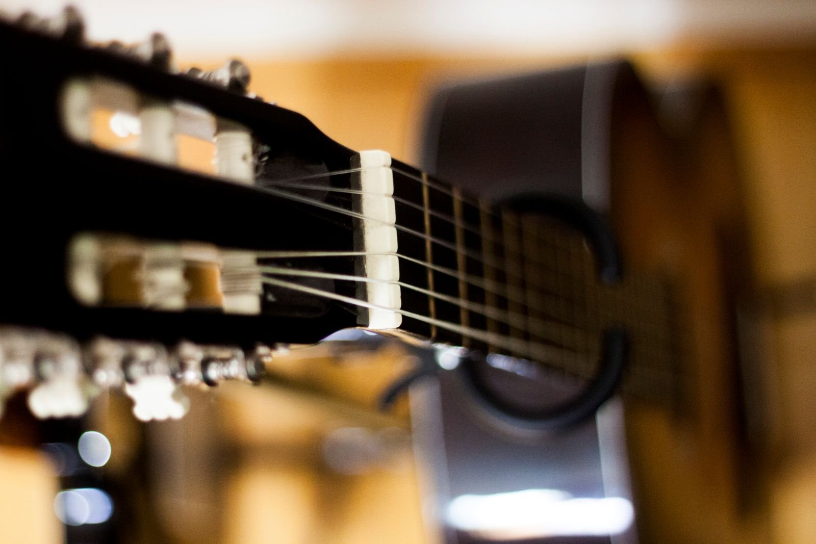Close-up of a classical guitar headstock with strings wound around the tuning pegs