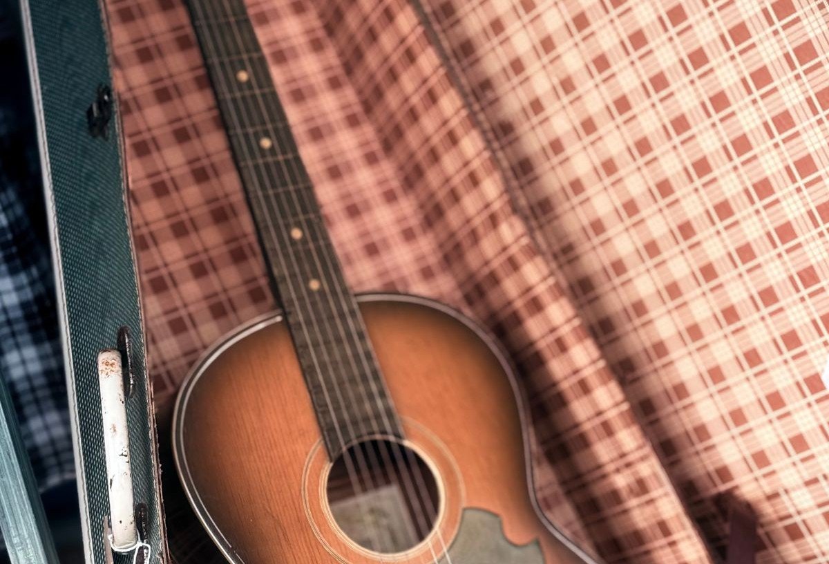A compact acoustic guitar resting inside its open case