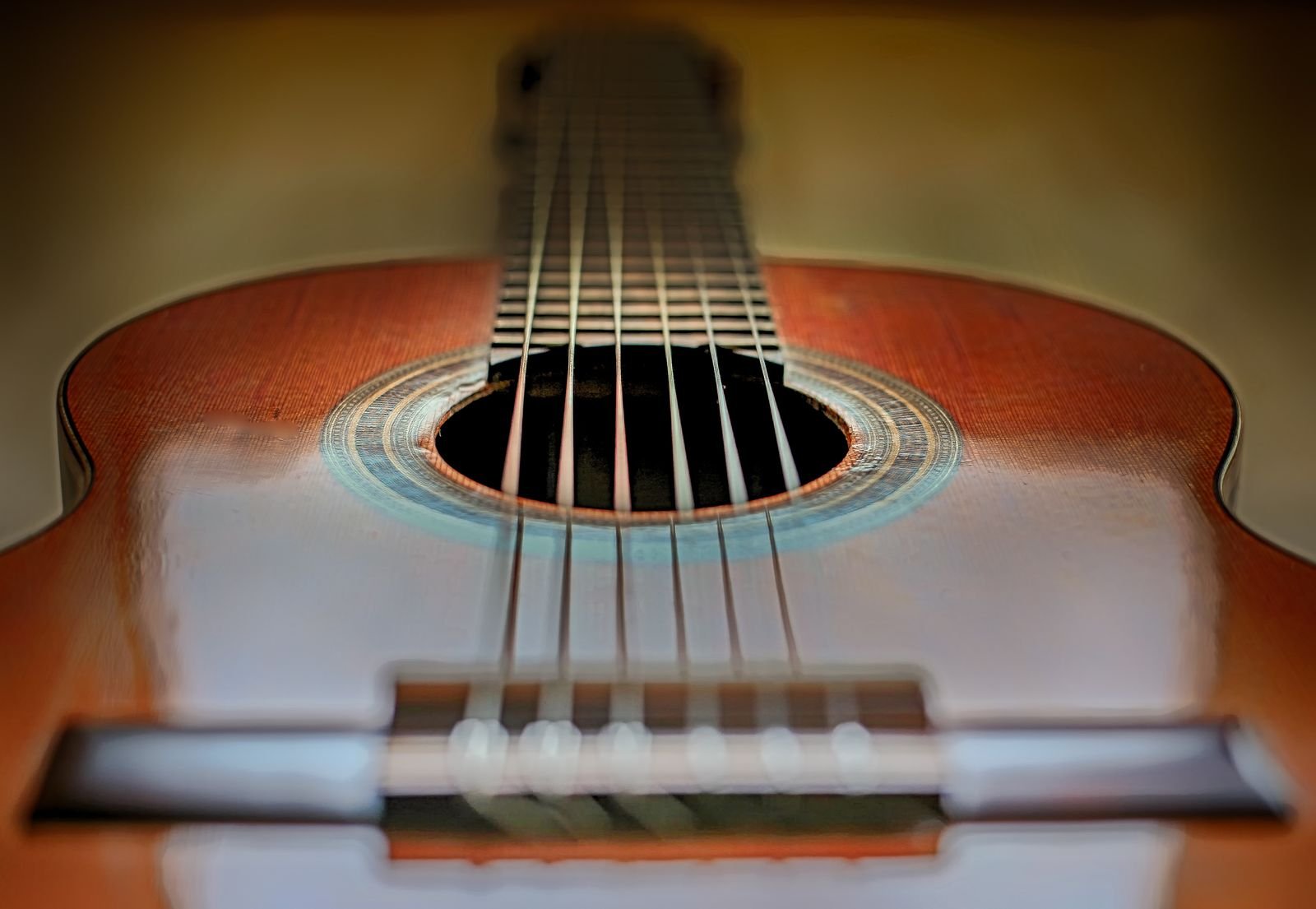 Close-up of an acoustic guitar's soundhole and strings, showing the detail lost on photos of smaller travel bodies