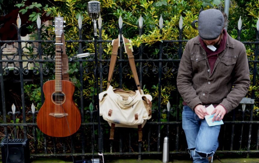 A guitar and travel bag leaning against a railing, the kind of road use a Martin Backpacker is built for