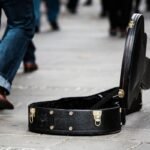 Guitar case on a city pavement, representing travel guitars on the move