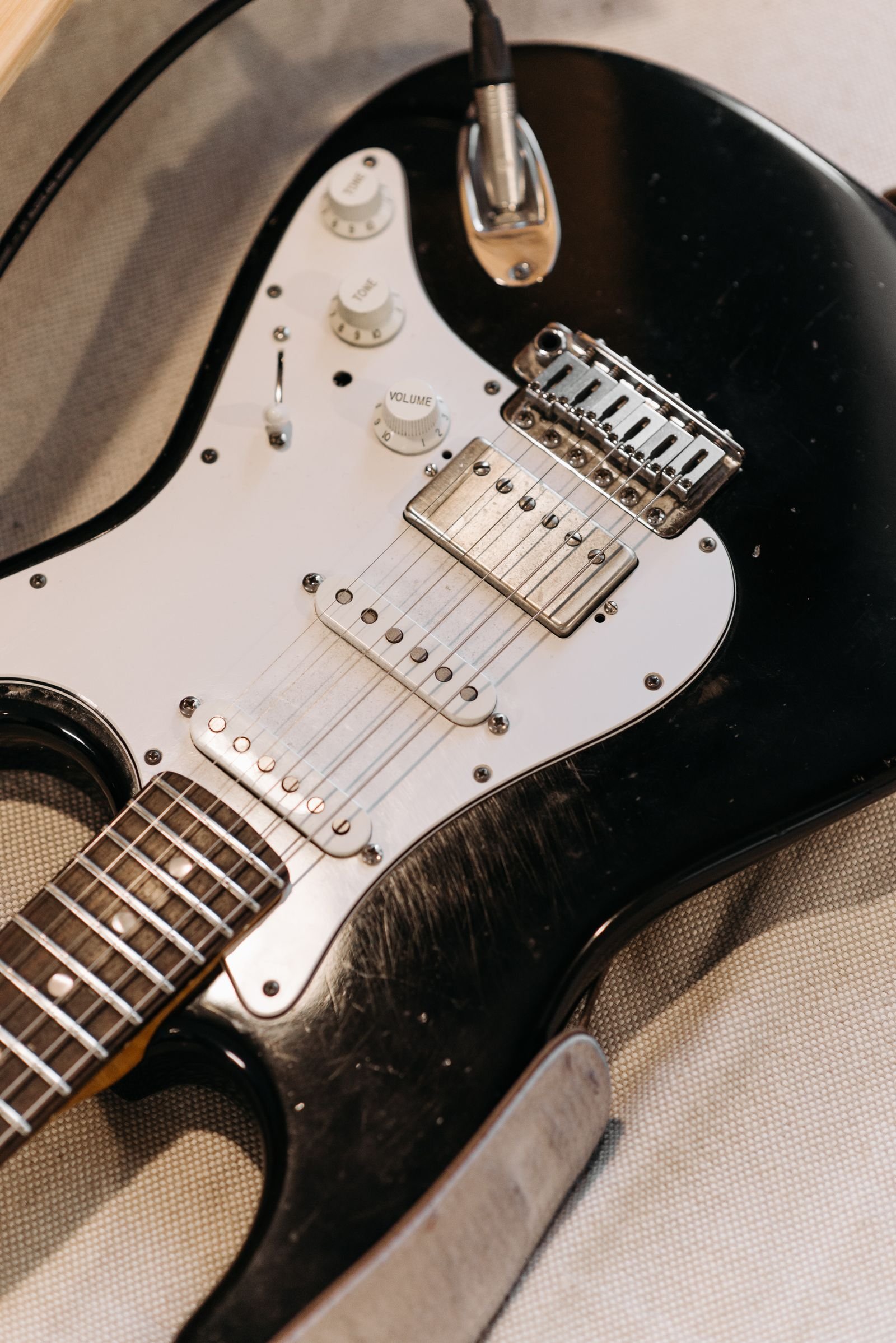 Close-up of a solid-body electric guitar's strings, bridge and control knobs