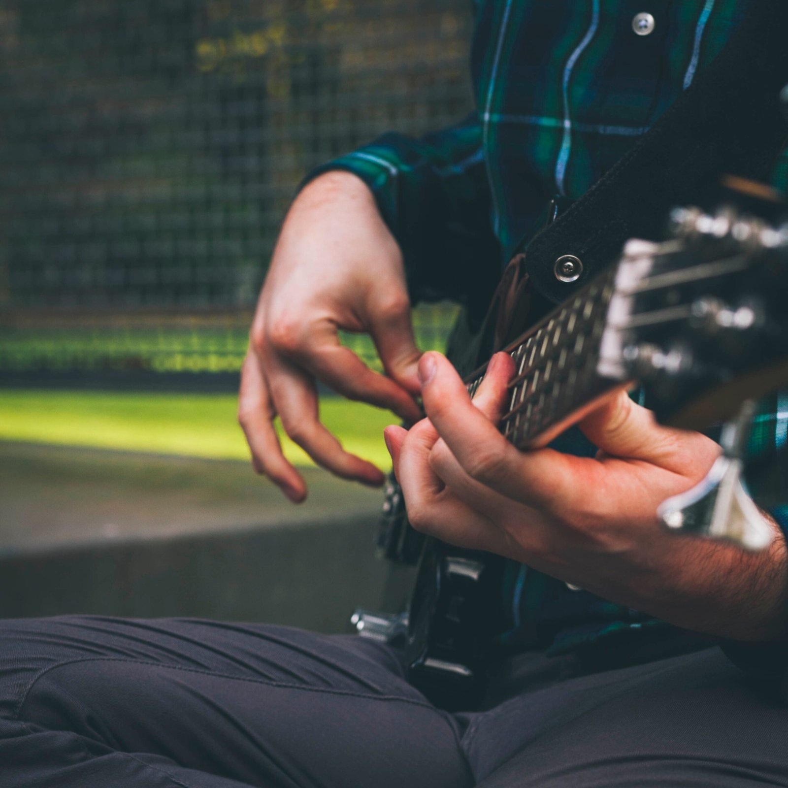 A musician's hands fingerpicking a bass guitar, illustrating the compact ultra-light travel bass format